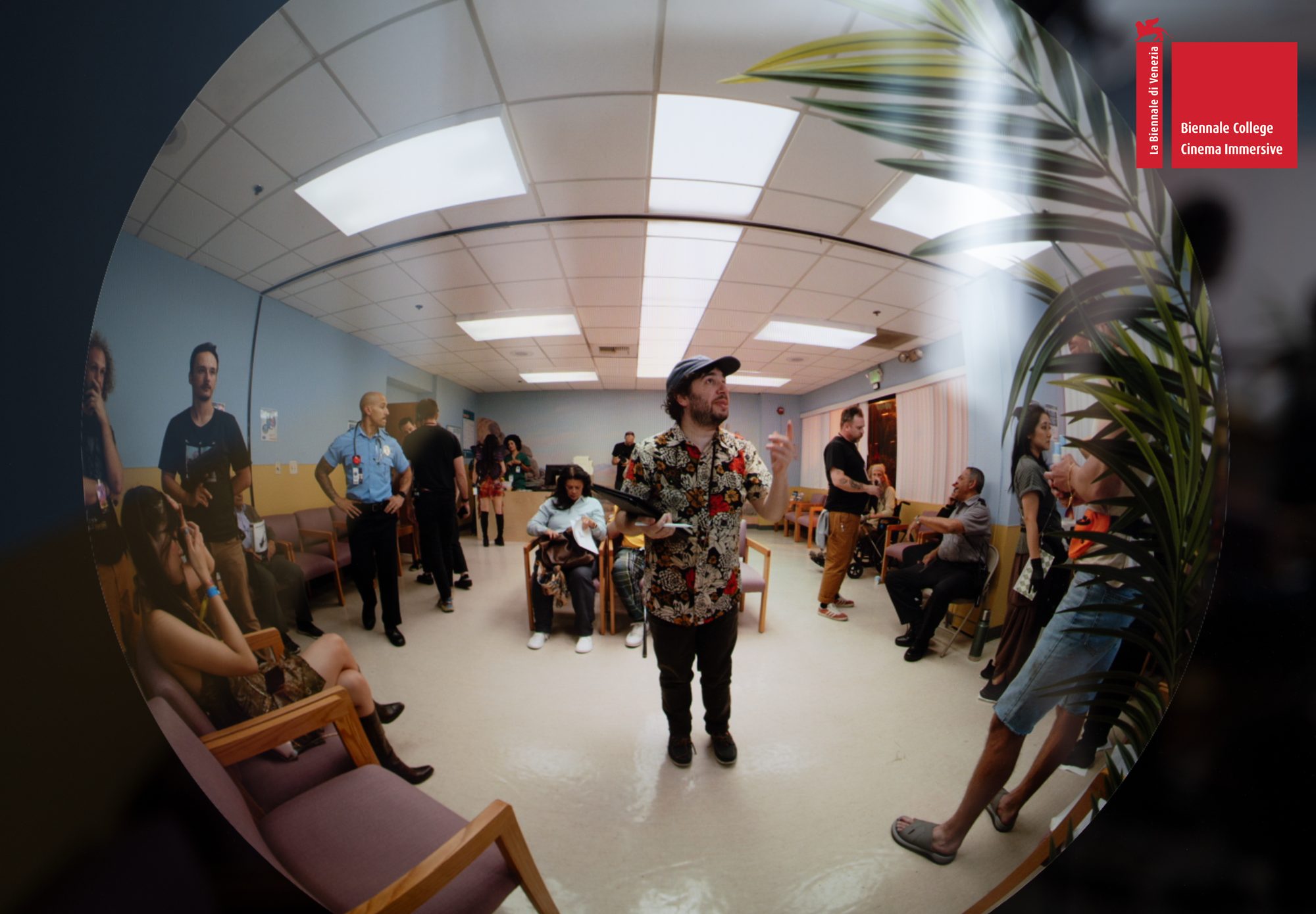 A crew member in a floral shirt on the waiting-room set, seen through the fisheye view of the immersive camera