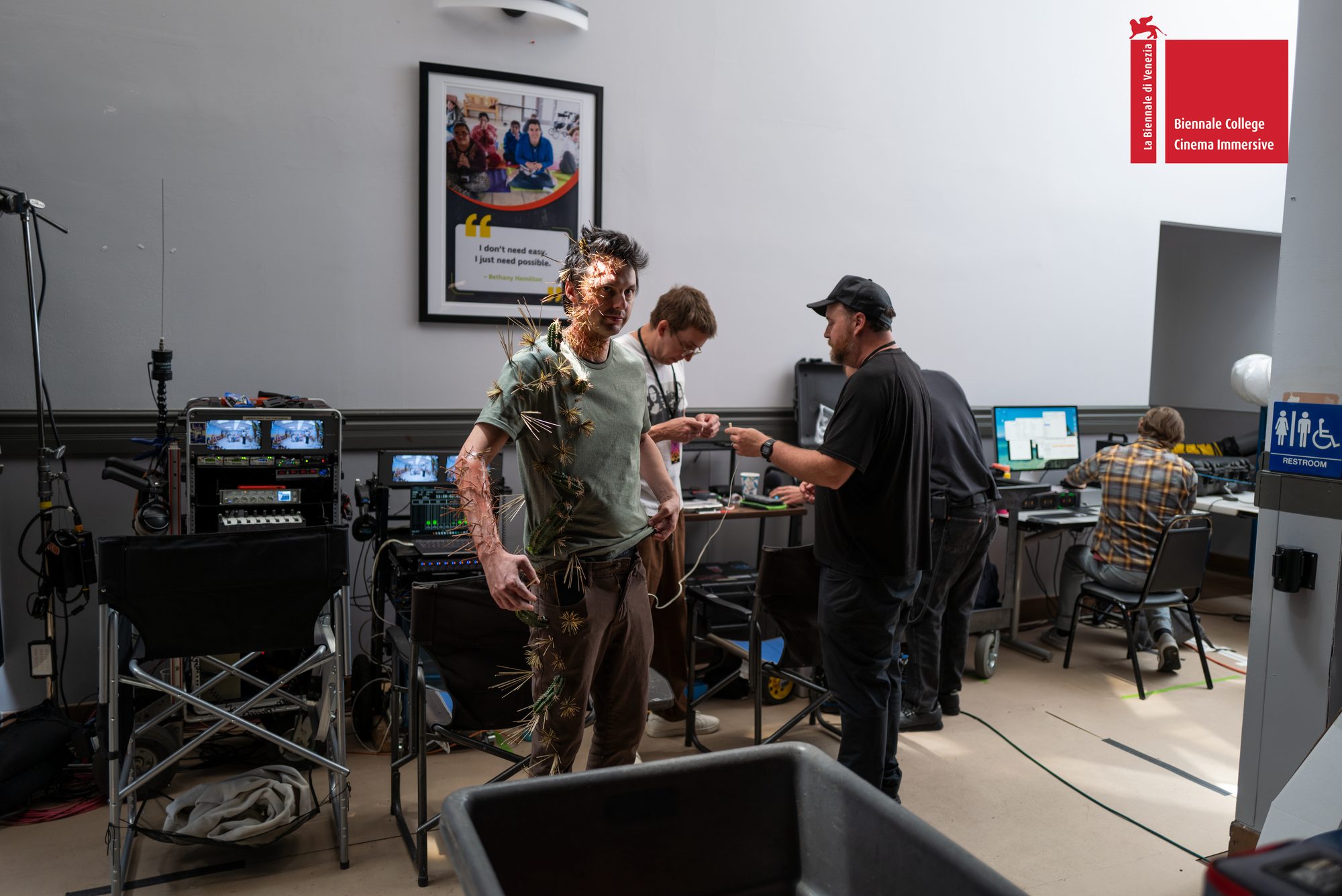 Crew members preparing a costumed actor beside the video village