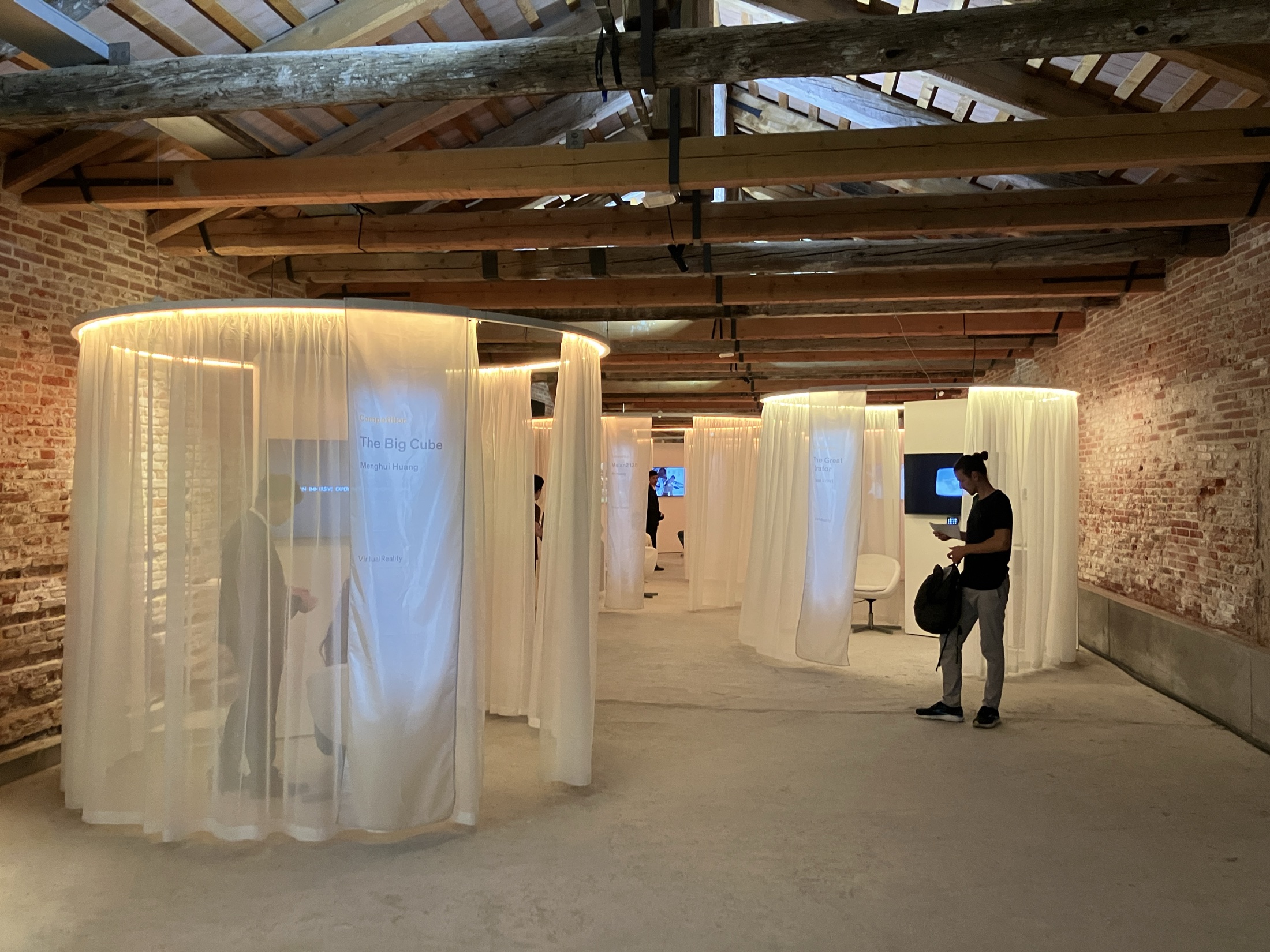 Circular fabric viewing booths inside the historic brick venue.