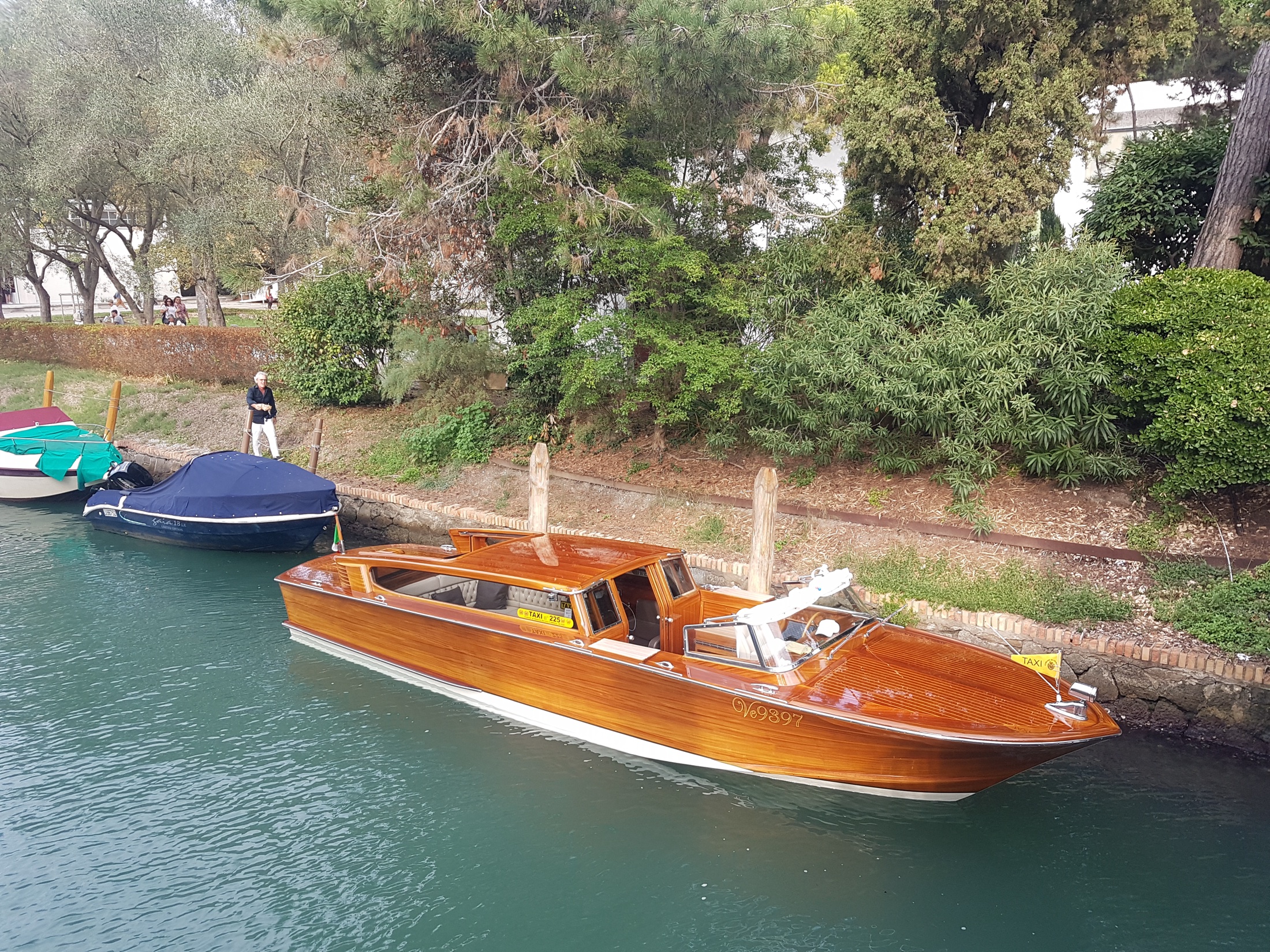 A polished wooden private water taxi on a Venetian canal.
